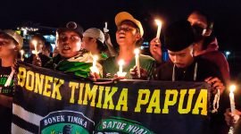Beberapa anggota Aliansi Suporter Mimika memegang lilin sembari menyanyikan lagu Sampai Jumpa dari Endank Soekamti.