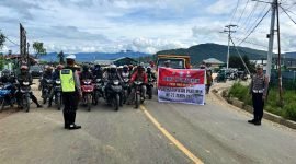 Anggota Satlantas Polres Paniai dan masyarakat (pengendara bermotor) ikut memperingati Hari Pahlawan dengan mengheningkan cipta secara serentak. (Foto: Humas Polres Paniai)