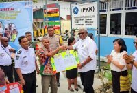Plt Bupati Mimika, Johannes Rettob, menyerahkan KTP secara simbolis kepada dua perwakilan warga Kelurahan Sempan, Distrik Mimika Baru dalam peluncuran Pos Adminduk.
