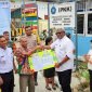 Plt Bupati Mimika, Johannes Rettob, menyerahkan KTP secara simbolis kepada dua perwakilan warga Kelurahan Sempan, Distrik Mimika Baru dalam peluncuran Pos Adminduk. 
