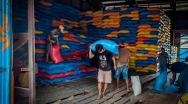 Tampak petugas sedang mengangkut beras di gudang Kantor Bulog Timika, Jalan Yos Sudarso, SP1, Distrik Wania, Mimika, Papua Tengah.