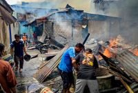 Masyarakat berjibaku membantu memadamkan api yang kian menjalar ke beberapa rumah lainnya di tembusan Jalan Seroja, Timika, Papua Tengah, Senin (6/3/2023) siang.