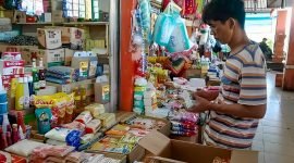 Erwin, pedagang sembako di Pasar Sentral Timika, sedang menata dagangannya, Senin (13/3/2023). 