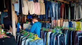 Seorang pedagang cakar bongkar di Jalan Hassanudin, Timika, Papua Tengah, sedang merapikan dagangannya, Selasa (21/3/2023). 