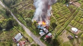 Tampak api dan asap mengepul di sebuah rumah samping tower Telkomsel yang berlokasi di Kampung Kago, Distrik Ilaga, Kabupaten Puncak, Papua Tengah, Selasa (15/8/2023). 