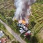 Tampak api dan asap mengepul di sebuah rumah samping tower Telkomsel yang berlokasi di Kampung Kago, Distrik Ilaga, Kabupaten Puncak, Papua Tengah, Selasa (15/8/2023). 