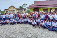 Foto bersama rombongan Kemenko PMK bersama siswa-siswi dan guru-guru di SMP Negeri 9 Kwamki Narama. (Foto: Galeri Papua/Jefri Manehat)