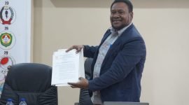 Ketua Tim Formatur sekaligus Ketua Harian KONI Kabupaten Mimika, Simon Kasamol, saat menunjukkan SK kepengurusan KONI Mimika masa bakti 2023-2027. (Foto: Galeri Papua/Endy Langobelen)