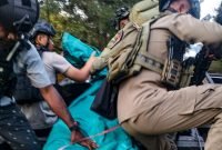 Aparat gabungan TNI-Polri saat mengevakuasi jenazah korban penyerangan KKB di Kampung Erogama, Distrik Omukia, Kabupaten Puncak. (Foto: Istimewa/Satgas Humas Damai Cartenz 2023)