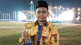Syahrul Maulana memegang piala yang baru dia raih usai menyabet juara II pada STQHN XXVII di Jambi. (Foto: Istimewa)