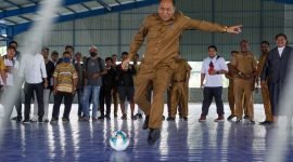 Penjabat Sekretaris Daerah Kabupaten Mimika, Robert Mayaut, menendang bola sebagai tanda dibukanya rangkaian perlombaan HUT ke-52 Korpri di GOR Futsal, Jalan Poros SP5, Timika Papua Tengah, Senin (13/11/2023). (Foto: Galeri Papua/Endy Langobelen)