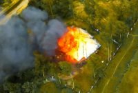 Tampak sebuah rumah dinas ASN Pemkab Intan Jaya di Kampung Mamba, Distrik Sugapa, diselimuti api dan kepulan asap. (Foto: Istimewa/Satgas Humas Damai Cartenz 2024)