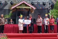Penjabat Gubernur Papua Tengah, Ribka Haluk, menyerahkan secara simbolis dana senilai Rp1 Miliar dan satu unit kapal cepat kepada Wakil Ketua Sinode GKI di Tanah Papua, Pdt Hizkia Rollo, Senin (5/2/2024) di Pulau Mansinam, Kabupaten Manokwari, Papua Barat. (Foto: Galeri Papua/Rahmat Julaini)