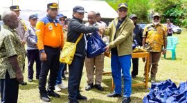 Mewakili Pemprov Papua Tengah, Staf Ahli Gubernur, Ukkas, menyerahkan bantuan sembako kepada Pj Bupati Puncak Jaya, H. Tumiran. (Foto: Istimewa/Prokompim Puncak Jaya) 