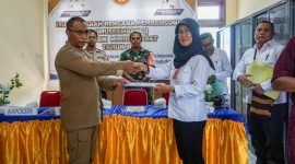 Kepala Distrik Mimika Barat, Christian P. Warinussy, menyerahkan usulan program-program kepada Tim Asistensi Bappeda Kabupaten Mimika, dalam hal ini Koordinator Musrenbang Distrik Mimika Barat, Musryah. (Foto: Galeri Papua/Endy Langobelen)