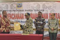 Kepala Bapperida Papua Tengah, Jull Eddy Way, S.Sos menyerahkan dokumen hasil Musrembang kepada Asisten 1 Bidang Pemerintahan dan Kesra Provinsi Papua Tengah, Drs Ausilius You, S.Pd, MM. (Foto: Galeri Papua/Moh. Wahyu Welerubun)