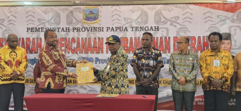 Kepala Bapperida Papua Tengah, Jull Eddy Way, S.Sos menyerahkan dokumen hasil Musrembang kepada Asisten 1 Bidang Pemerintahan dan Kesra Provinsi Papua Tengah, Drs Ausilius You, S.Pd, MM. (Foto: Galeri Papua/Moh. Wahyu Welerubun)
