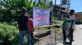 Lurah Inauga, Gerson Rumbarar bersama sejumlah pegawai kelurahan memasang spanduk larangan membuang sampah di salah satu TPS liar, di Jalan Samratulangi, Jalur 4, Kelurahan Inauga, Distrik Wania, Mimika, Papua Tengah, Jumat (26/4/2024). (Foto: Galeri Papua/Moh. Wahyu Welerubun)
