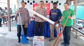 Kapolsek Mimika Baru, AKP J. Limbong menyerahkan bantuan peralatan kebersihan kepada Ketua Karangtaruna Pemuda Inauga. (Foto: Galeri Papua/Moh. Wahyu Welerubun)