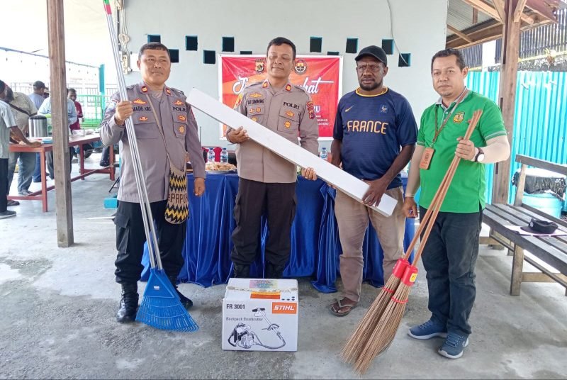 Kapolsek Mimika Baru, AKP J. Limbong menyerahkan bantuan peralatan kebersihan kepada Ketua Karangtaruna Pemuda Inauga. (Foto: Galeri Papua/Moh. Wahyu Welerubun)