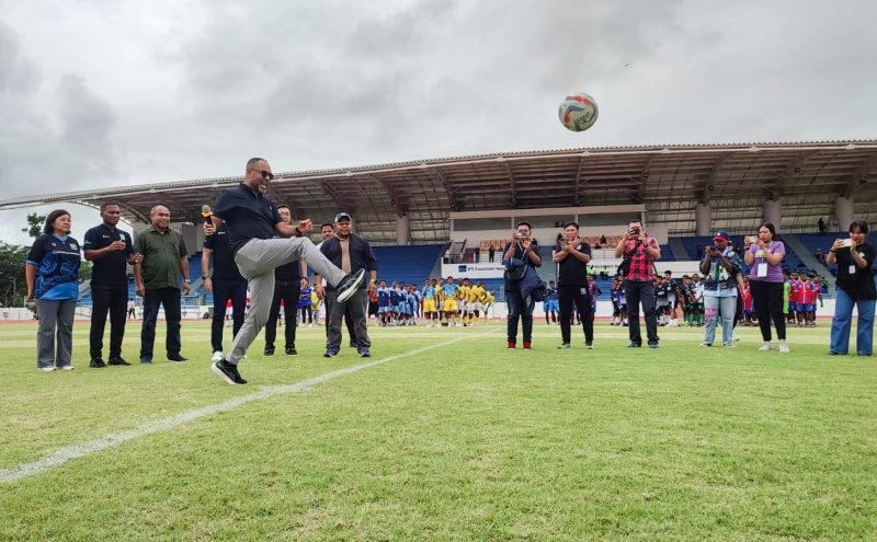 Direktur & Executive Vice President Sustainable Development PT Freeport Indonesia, Claus Wamafma, membuka Freeport Junior Cup 2024 dengan melakukan tendangan perdana. (Foto: Galeri Papua/Endy Langobelen)