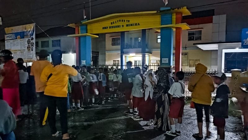 Tampak sejumlah anak berseragam merah putih ditemani orang tua mengantre di depan gerbang SMP Negeri 2, Timika, Papua Tengah, Senin (24/6/2024), untuk mendapatkan formulir PPDB. (Foto: Galeri Papua/Endy Langobelen)