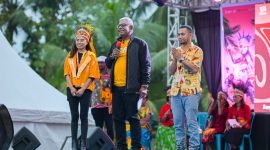 Pelaksana Tugas Bupati Mimika, Johannes Rettob, saat membawakan sambutan dalam pembukaan TIFA 2024 didampingi Alfo Smith dan Dina Merani, Kamis (18/7/2024). (Foto: Istimewa/Dokumentasi TIFA 2024)