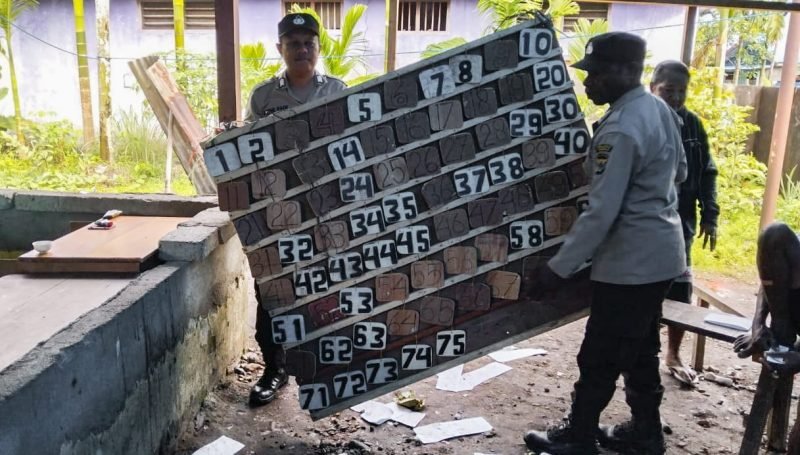Personel Polsek Mimika Baru mengamankan barang bukti di salah satu titik tempat permainan judi king di Timika, Papua Tengah. (Foto: Istimewa/Humas Polsek Mimika Baru)