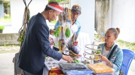 Kepala Dinas Kependudukan dan Pencatatan Sipil Kabupaten Mimika, Slamet Sutedjo, saat melihat produk-produk milik Wadomu Art di Dukcapil Festival. (Foto: Istimewa/Panitia Dukcapil Festival)