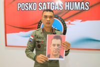 Kasatgas Humas Ops Damai Cartenz 2024, Kombes Pol. Bayu Suseno, memegang foto Pilot Selandia Baru, Glen Malcolm Conning. (Foto: Istimewa/Satgas Humas Operasi Damai Cartenz 2024)