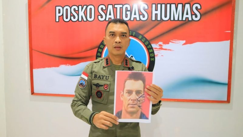 Kasatgas Humas Ops Damai Cartenz 2024, Kombes Pol. Bayu Suseno, memegang foto Pilot Selandia Baru, Glen Malcolm Conning. (Foto: Istimewa/Satgas Humas Operasi Damai Cartenz 2024)