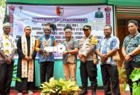 Pj Bupati Mappi, Michael R. Gomar, secara simbolis menyerahkan kunci rumah kepada salah satu masyarakat penerima manfaat. (Foto: Istimewa/Humas Pemkab Mappi)