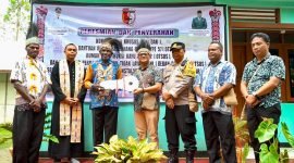 Pj Bupati Mappi, Michael R. Gomar, secara simbolis menyerahkan kunci rumah kepada salah satu masyarakat penerima manfaat. (Foto: Istimewa/Humas Pemkab Mappi)