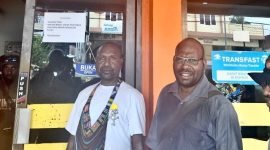 Joni Kobogau (kaos putih) didampingi seorang pria sedang berpose. (Foto: Galeri Papua/Wahyu)