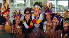 Penjabat Bupati Kabupaten Mimika, Valentinus Sudarjanto Sumito, dan sang istri foto bersama para penari di depan Ruang Kedatangan Bandara Mozes Kilangin, Timika, Papua Tengah, Minggu (6/9/2024). (Foto: Galeri Papua/Endy Langobelen)