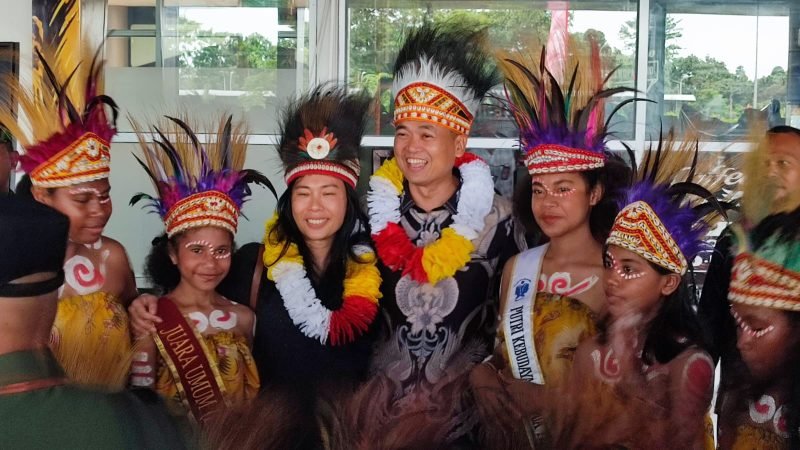 Penjabat Bupati Kabupaten Mimika, Valentinus Sudarjanto Sumito, dan sang istri foto bersama para penari di depan Ruang Kedatangan Bandara Mozes Kilangin, Timika, Papua Tengah, Minggu (6/9/2024). (Foto: Galeri Papua/Endy Langobelen)