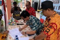 Kepala Distrik Wania, Mathius Sedan, saat menandatangani surat keputusan (SK) pencanangan Kelurahan Inauga BERSINAR Tahun 2024 pada acara pencanangan yang berlangsung di Kantor Kelurahan Inauga, Kamis (12/9/2024). (Foto: Galeri Papua/Wahyu)