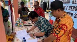 Kepala Distrik Wania, Mathius Sedan, saat menandatangani surat keputusan (SK) pencanangan Kelurahan Inauga BERSINAR Tahun 2024 pada acara pencanangan yang berlangsung di Kantor Kelurahan Inauga, Kamis (12/9/2024). (Foto: Galeri Papua/Wahyu)