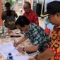 Kepala Distrik Wania, Mathius Sedan, saat menandatangani surat keputusan (SK) pencanangan Kelurahan Inauga BERSINAR Tahun 2024 pada acara pencanangan yang berlangsung di Kantor Kelurahan Inauga, Kamis (12/9/2024). (Foto: Galeri Papua/Wahyu)