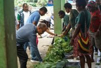 Calon Wakil Bupati Mimika nomor urut 3, Yusuf Rombe Pasarrin, SAk., belanja sayur milik mama-mama Papua di Pasar Sentral Timika. (Foto: Istimewa/Tim AIYE)
