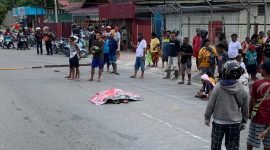 Tampak pria lansia yang tergeletak di tengah jalan dan ditutup menggunakan tikar. (Foto: Galeri Papua/Wahyu)