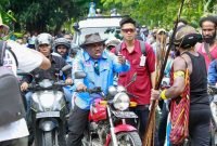 Calon Bupati Mimika, Maximus Tipagau, menggunakan sepeda motor menyambangi warga di Kwamki Narama. (Foto: Istimewa/Tim MP3)