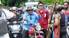 Calon Bupati Mimika, Maximus Tipagau, menggunakan sepeda motor menyambangi warga di Kwamki Narama. (Foto: Istimewa/Tim MP3)
