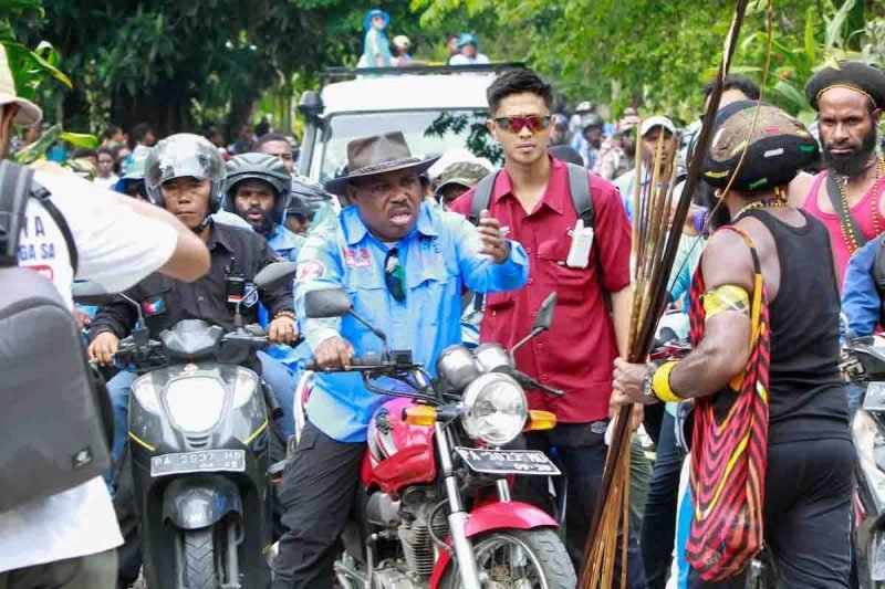 Calon Bupati Mimika, Maximus Tipagau, menggunakan sepeda motor menyambangi warga di Kwamki Narama. (Foto: Istimewa/Tim MP3)