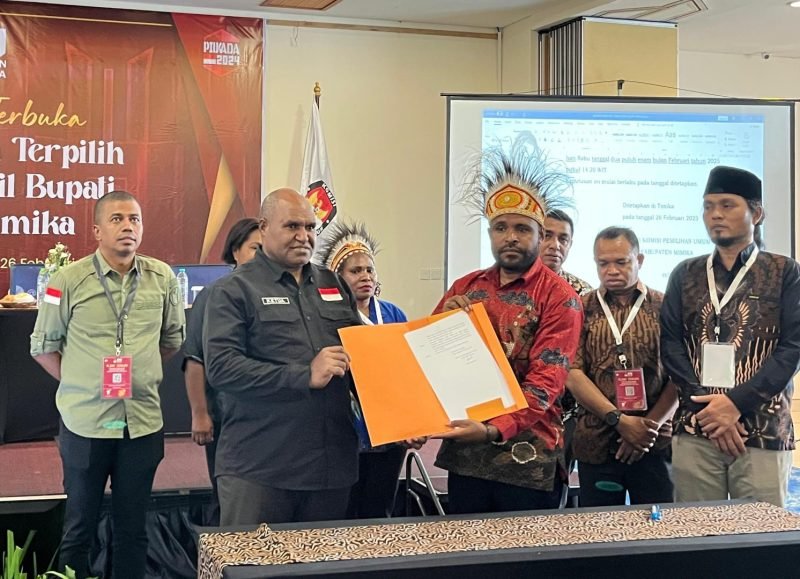 Momen penyerahan salinan SK oleh KPU (Kanan) kepada Ketua Bawaslu (Kiri) dalam rapat pleno terbuka penetapan calon terpilih Bupati dan Wakil Bupati Kabupaten Mimika di hotel Horison Ultima Timika, Rabu (26/2/2025). (Foto: Istimewa)