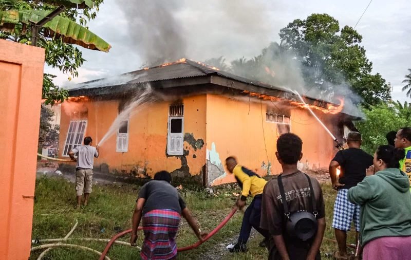 Petugas Damkar bersama warga berupaya memadamkan api yang membakar sebuah rumah di Jalur 3, SP2, Mimika, Papua Tengah, Kamis (6/3/2025). (Foto: Istimewa)