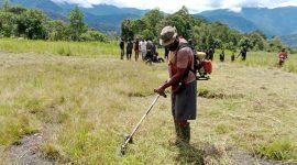 Warga bersama TNI Polri membersihkan lapangan terbang di Distrik Jila. (Foto: Istimewa)