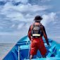 Seorang petugas SAR sedang berdiri di tengah perahu mengamati sekitaran permukaan laut dalam pencarian Long Boat hilang kontak di perairan Lakahia Kaimana. (Foto: Istimewa/SAR Timika)