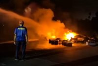 Petugas damkar berupaya memadamkan api yang melahap sejumlah ban di landasan pacu Bandara Lama Nabire. (Foto: Istimewa/Tangkapan layar video)