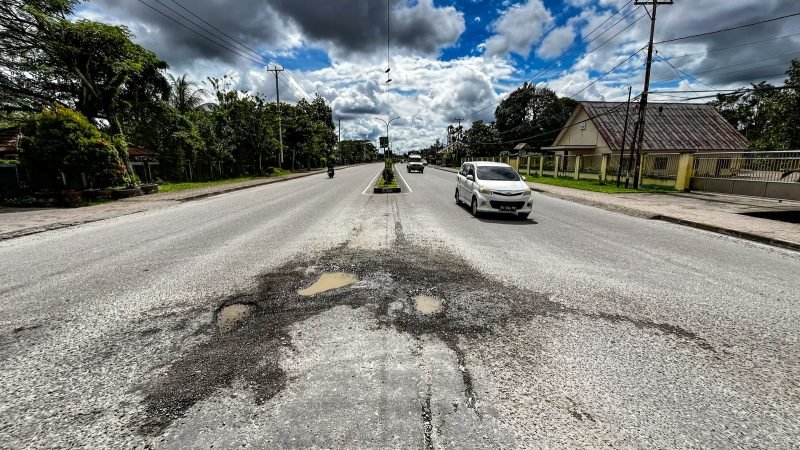 Jalan berlubang di kapsul putar balik depan Perumahan Pemda SP2, Mimika, Papua Tengah. (Foto: Galeri Papua/Endy Langobelen)